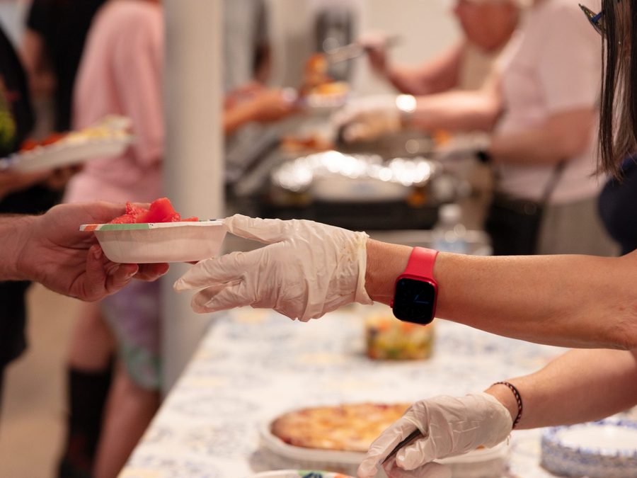 A volunteer serving a meal to a guest at the shelter