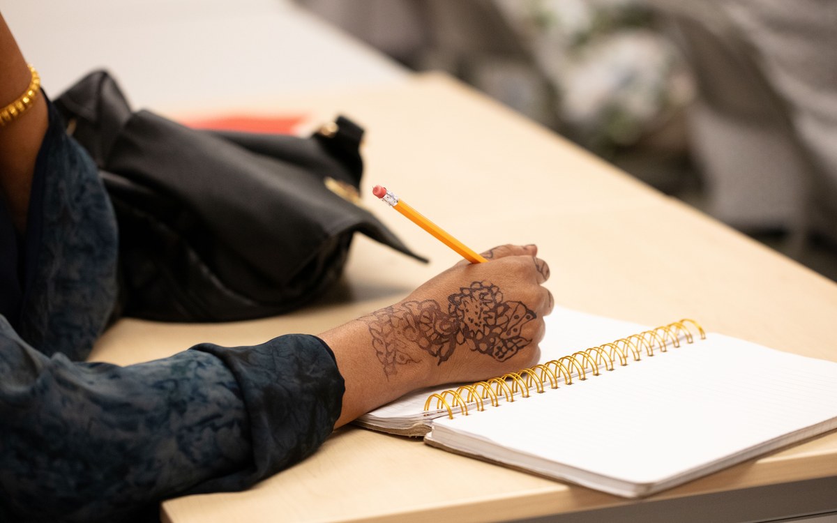 An adult learner taking notes in class at the English Learning Center