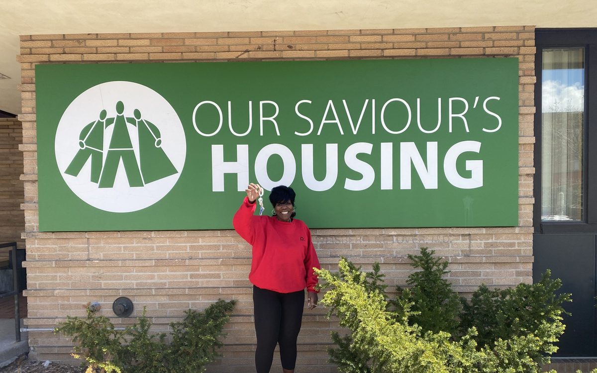 A resident holds the keys to her new apartment outside the shelter