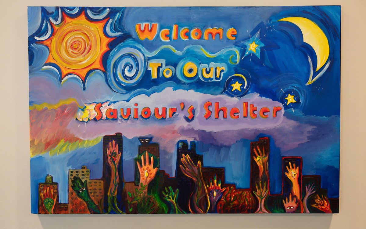 A painting that reads Welcome To Our Saviour's Shelter, hanging in the shelter